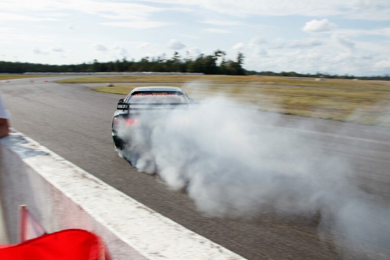 A car with smoke in behind on a race track