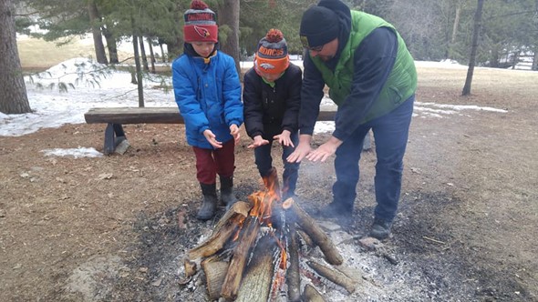 Family warming up by fire