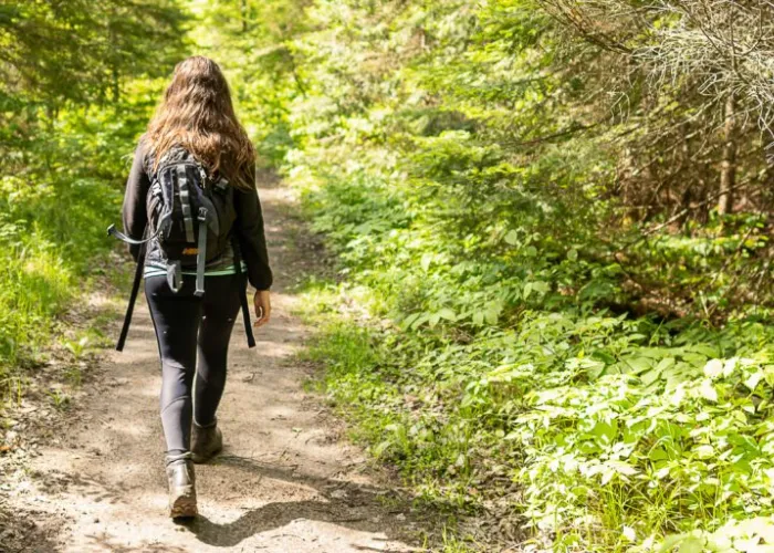 Woman walking along a trail in the woods