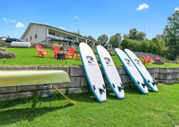 Canoe and Paddle Boards lined up on the Lakeshore at Baptise Lodge on Baptise Lake, Ontario